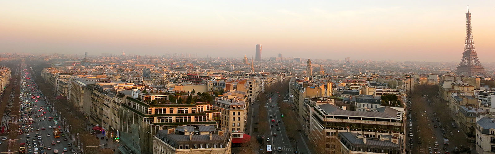 View of the Paris skyline at sunset. the Eiffel tower is in the background with the other city buildings in the foreground.